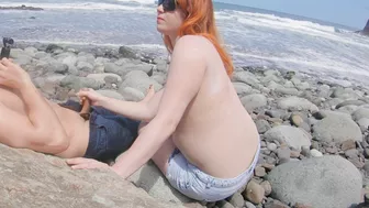Red-haired babe gives blowjob and handjob on public beach.
