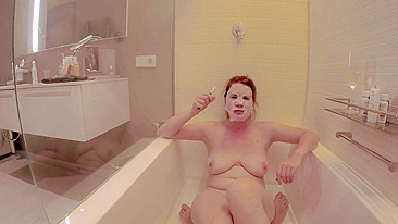 Big titted ginger redhead foot slave enjoys sensual feet spa and toe job while smoking in a bath tub.