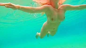 Curvy ginger teen swims nude and pees in sea.