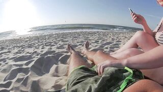 Risky public beach handjob interrupted by approaching surfers.