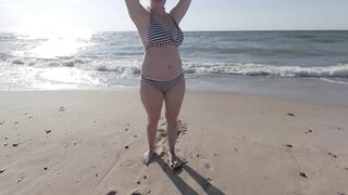 Risky public beach handjob interrupted by approaching surfers.