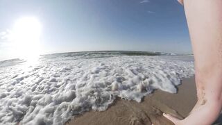 Risky public beach handjob interrupted by approaching surfers.