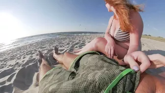 Risky public beach handjob interrupted by approaching surfers.