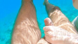 Redhead teen swims nude underwater while receiving a hand job from her gorgeous partner.