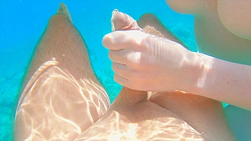 Redhead teen swims nude underwater while receiving a hand job from her gorgeous partner.