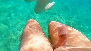 Redhead teen swims nude underwater while receiving a hand job from her gorgeous partner.