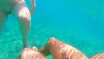 Redhead teen swims nude underwater while receiving a hand job from her gorgeous partner.