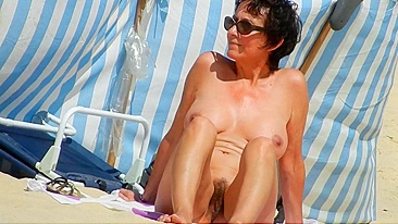 A Mature, Hairy Nudist Woman Enjoys Beach Time With Her Natural Pussy