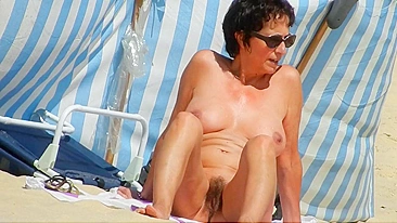 A Mature, Hairy Nudist Woman Enjoys Beach Time With Her Natural Pussy