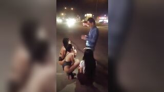 Guy receives blowjob from three women in public place on sidewalk