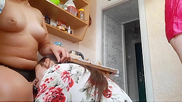 Lesbian woman fucking with a strap on her girlfriend in the kitchen