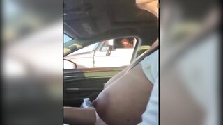 Woman driving topless in car on a public road for everyone to see